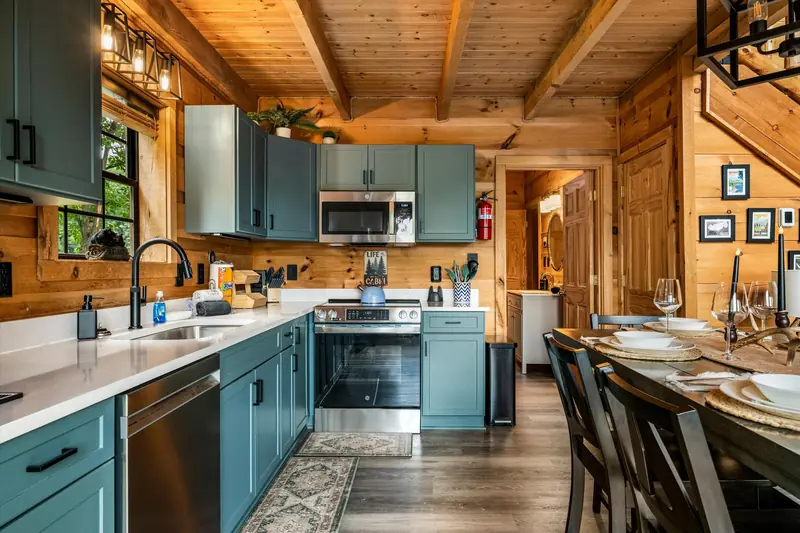 Kitchen at Acorn Ridge with sage green cabinets, range and stainless appliances